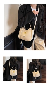 Detail of off-white lychee grain leather tote with gold buckle and tassel charm