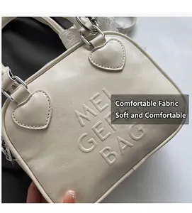 Dettaglio della borsa bowling crema con goffratura MEI GEI BAG e accenti in metallo a cuore