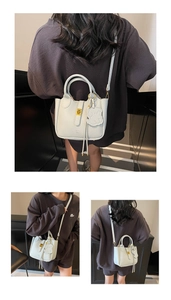 Detail of light blue textured leather tote with gold twist lock and dog charm