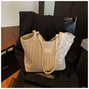 Detailed macro view of woven beige straw tote texture with leather strap and lace scarf