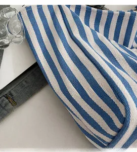 Detailed close-up of blue and white striped knit canvas fabric with fine twill texture