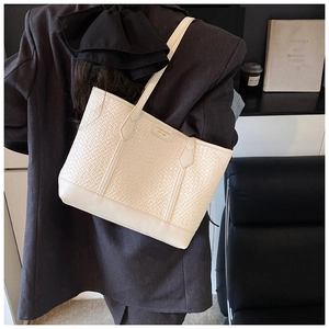 Détail du sac cabas tissé crème avec bandoulières en cuir lisse et logo de la marque