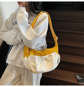 Detail of canvas bag drawstring closure and yellow contrast strap on wooden stairs