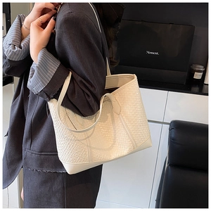 Détail du sac cabas blanc en similicuir gaufré avec texture tissée et bandoulière élégante