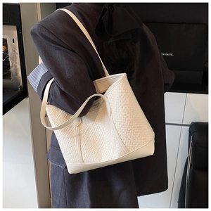 Détail de la texture tressée ivoire sur un grand sac cabas avec de longues lanières