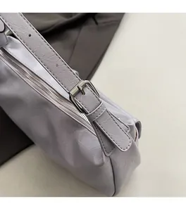 Close-up of lavender shoulder bag featuring vintage cracked leather and silver metal buckles