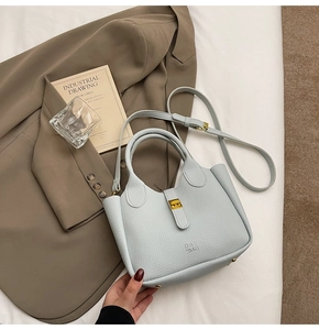 Detail of light blue pebble leather tote bag with gold twist lock and adjustable strap