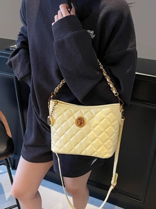Pale yellow quilted leather tote bag with chain strap and metal swivel lock