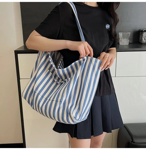Close-up of a blue and white striped canvas tote bag showing thick cotton fabric and straps