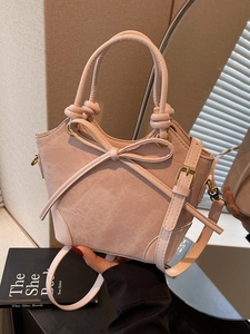 Pink faux suede bucket bag with leather bow and knotted handle for women