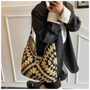 Close-up of woven checkerboard straw tote bag with zipper and contrast patterns