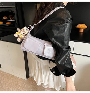 Detail of lavender underarm bag with front double pockets and adjustable shoulder strap