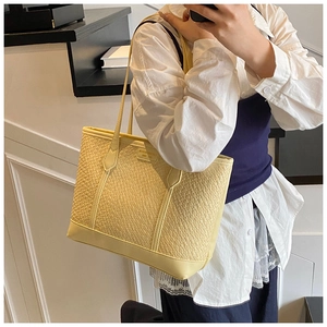 Détail du sac cabas jaune crème montrant la texture tissée et les fines bandoulières