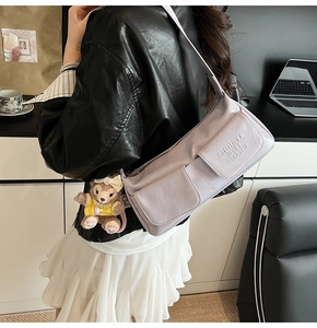 Detail of lilac shoulder bag with dual front cargo pockets and pebbled leather texture