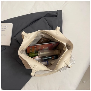 Top view showing large capacity woven tote bag interior with tablet and daily cosmetics