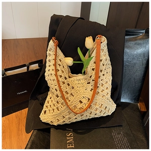 Detail of hand-woven beige crochet tote bag with orange leather strap and floral hollow pattern