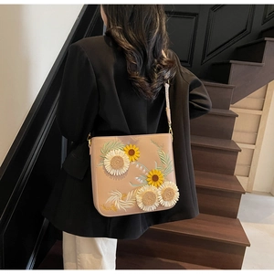 Detail of sunflower and daisy 3D embroidery on beige crossbody bucket bag for women