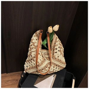 Detail of bohemian crochet straw tote with premium leather strap and metal ring connectors