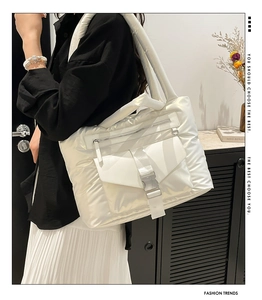 Dettaglio della borsa tote in nylon trapuntato bianco con tasca frontale a fibbia e zip metallica