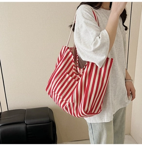 Detailed view of striped canvas tote bag showing front pocket and woven texture