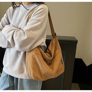 Detail of CHUANGUI brown canvas tote messenger bag with adjustable strap and embossed label