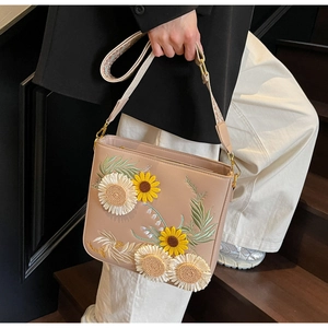 Detail of 3D sunflower embroidery on bucket bag with patterned wide strap