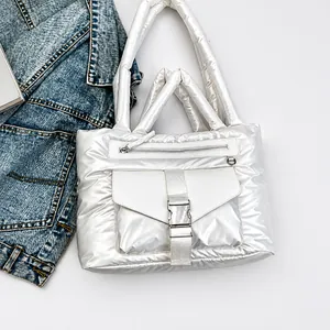 Detail of white quilted nylon tote bag with buckle pocket and padded top handles