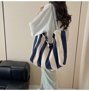 Close-up of a large capacity canvas tote bag with classic vertical stripes and strap
