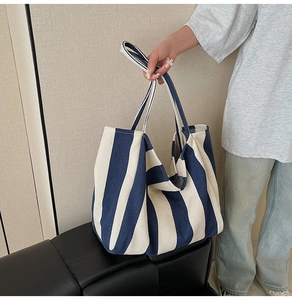 Detail showing high-capacity striped canvas tote bag in navy blue and off-white