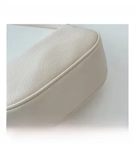 Detailed close-up of premium lychee texture and stitching on cream white tote bag