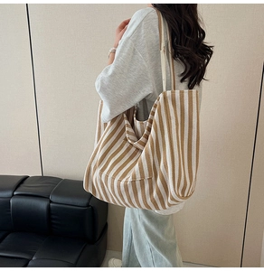 Detail view of large striped canvas tote bag showing capacity and over-the-shoulder fit