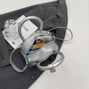 Silver metallic circular handbag on gray blazer with adjustable strap and silver hardware