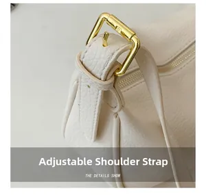 Close-up of adjustable strap with gold-tone hardware on a textured leather tote bag
