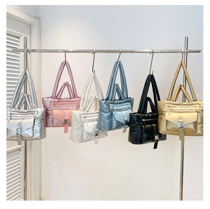 Dettaglio di borse tote trapuntate in vari colori metallizzati con tasche a cerniera