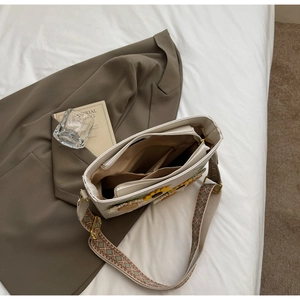 Detail view of white tote bag interior with zipper pocket and sunflower embroidery