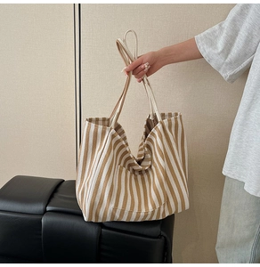 Detail of striped canvas tote bag showing the thick fabric texture and shoulder strap