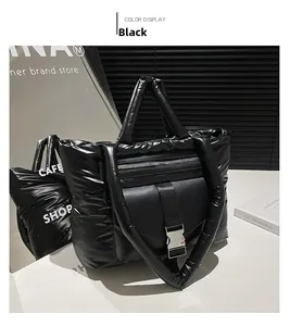 Dettaglio della borsa shopper nera lucida trapuntata con fibbia in metallo e tracolla