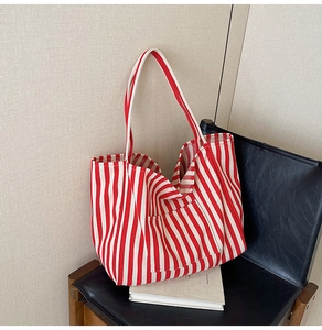 Detailed close-up of a red and white striped canvas tote bag resting on a chair