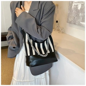 Detail of striped crossbody bag with chunky silver chain and black leather trim