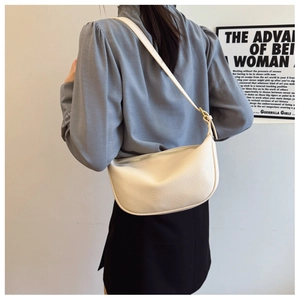 Close-up of creamy white half-moon shoulder bag showing荔枝 texture and minimalist style