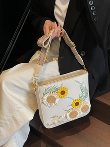 White bucket bag with sunflower embroidery and geometric woven shoulder strap
