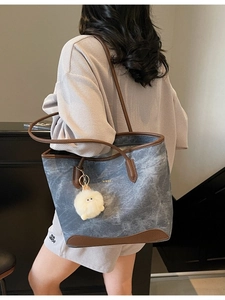 Minimalist large-capacity tote bag in textured blue fabric with brown leather trim details