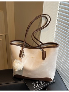 Large capacity beige and brown tote bag with leather straps and plush charm accessory
