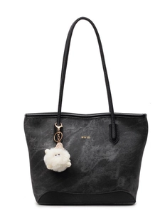 Minimalist black tote bag with textured surface and cute white plush charm on white background