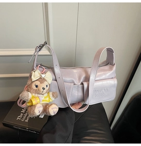 Detail of light purple underarm bag featuring utility pockets and a cute teddy charm