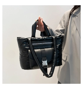 Dettaglio della borsa tote in nylon trapuntato nero con fibbia in metallo e tasca a zip