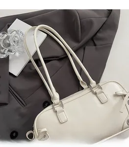 Dettaglio borsa a spalla in pelle crema con finiture argento su blazer grigio