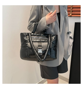 Vista dettagliata della borsa a sbuffo in nylon nero trapuntato con fibbia in metallo
