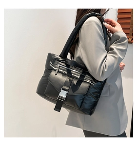 Vista laterale della borsa tote trapuntata in nylon nero con fibbia in metallo
