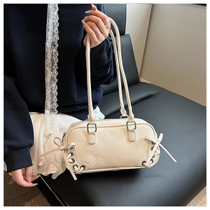 Detail of cream PU leather handbag with side lace-up bows and silver metal eyelets